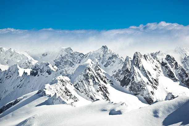 swiss alps view over misty mountains from mount titlis, engelberg, switzerland. 3200m above sea level. snow mountain range european alps mountain peak stock pictures, royalty-free photos & images