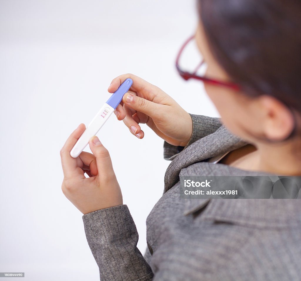 Mujer de negocios mirando a una prueba de embarazo - Foto de stock de Adulto libre de derechos