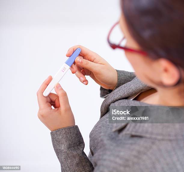 Mujer De Negocios Mirando A Una Prueba De Embarazo Foto de stock y más banco de imágenes de Adulto - Adulto, Adulto de mediana edad, Adulto joven