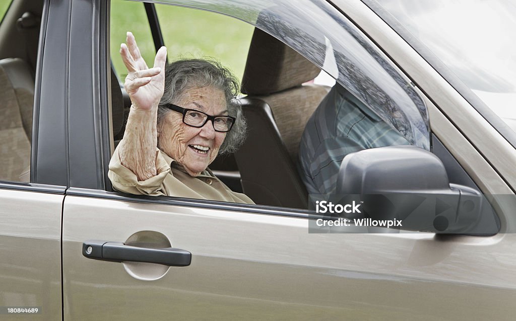 Senior femme agitant de la fenêtre de la voiture - Photo de Conduire libre de droits