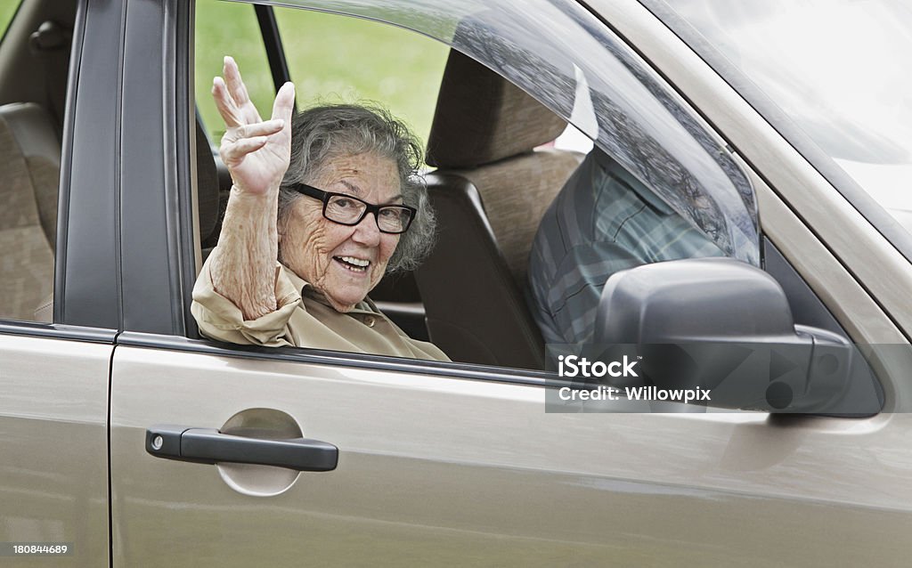 Пожилая женщина размахивающий лапами из окна автомобиля - Стоковые фото Водить роялти-фри