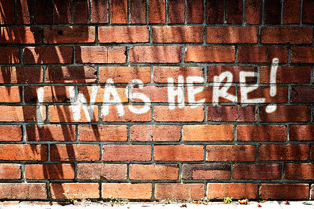 istock I WAS HERE! says graffiti on sunlit brick wall 180845244