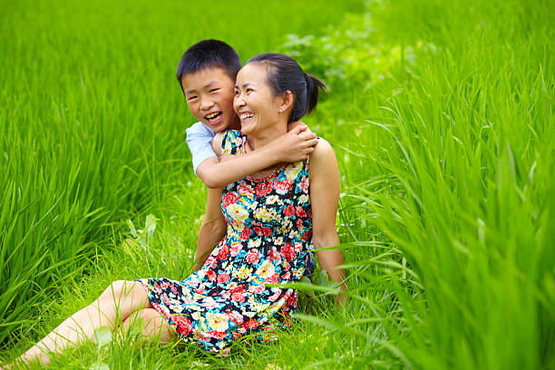 istock happy little boy holding his mother in rice paddy 180845741