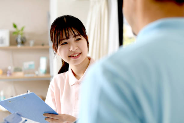 a young asian female staff member wearing business wear and a middle-aged asian male staff member have a discussion. - polo shirt two people men working imagens e fotografias de stock