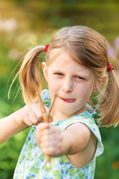 istock Girl Aiming Slingshot At Camera 180846484