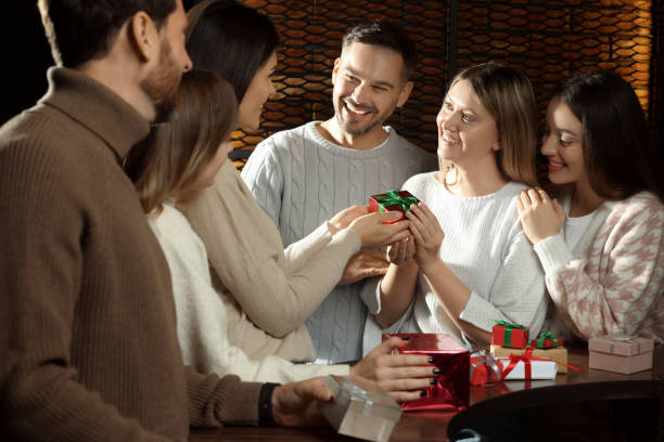 istock Friends exchanging gifts at table in cafe 1808468120