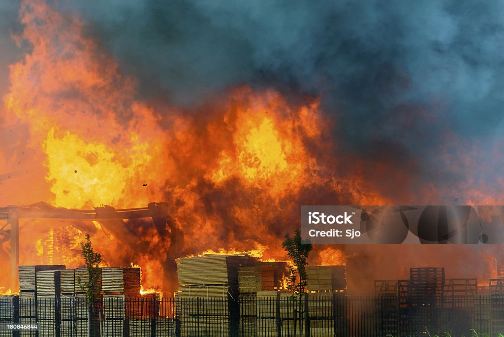 Factory burning in industrial area Huge flames coming from a pallet factory on fire in an industrial area in the town of Kampen in The Netherlands. Fire - Natural Phenomenon Stock Photo