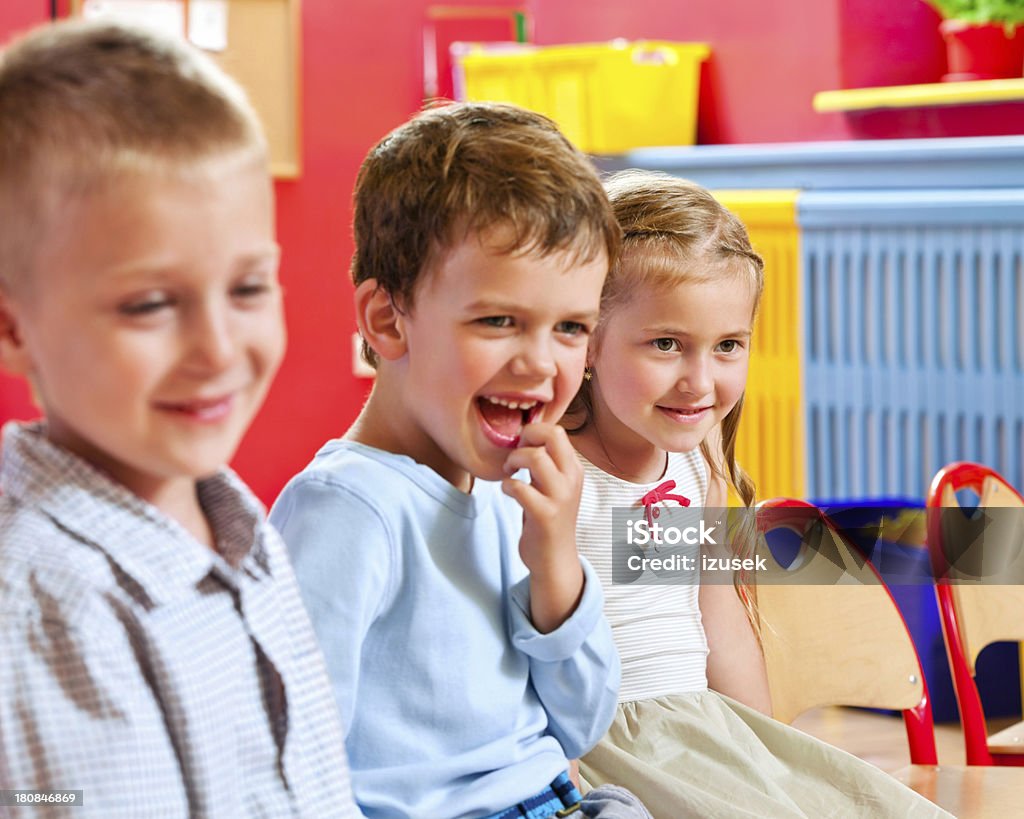 Cute Nursery School Children A happy children sitting in a playroom in a nursery school and smiling. 4-5 Years Stock Photo