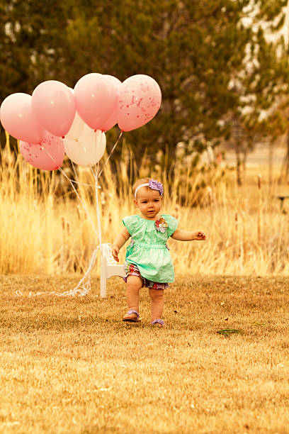 istock Baby girl with balloons 180847040