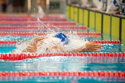 Swimmer swims breaststroke swimming style in the pool