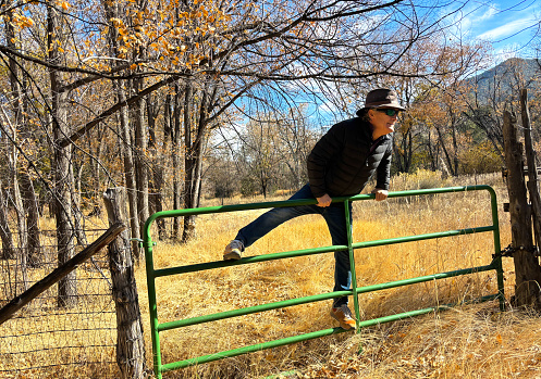 Santa Fe, NM: Senior Man Clambers Over Fence