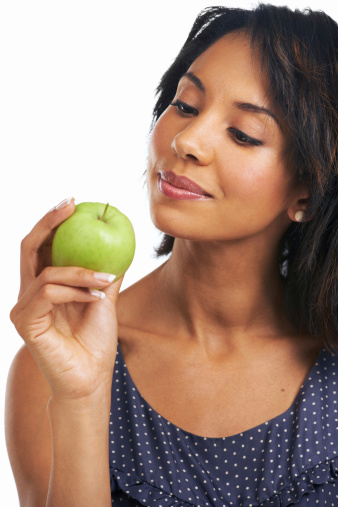 A pretty young woman holding a fresh apple