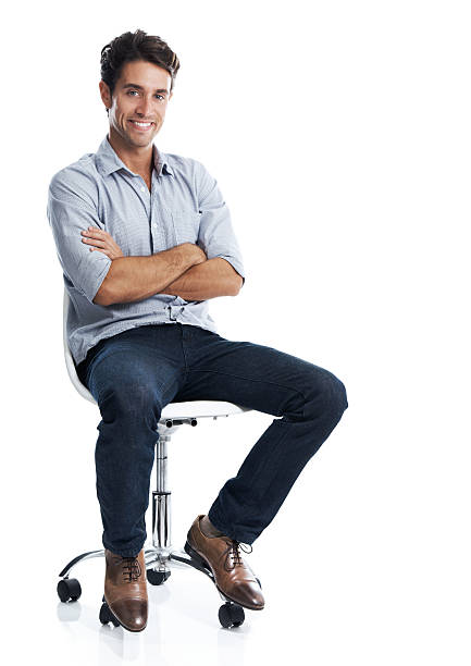 I go through life at my own pace Handsome young man smiling while sitting on a chair - isolated on white office chair stock pictures, royalty-free photos & images