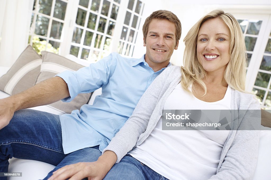 We love our new home Portrait of a smiling couple sitting on the couch 40-44 Years Stock Photo