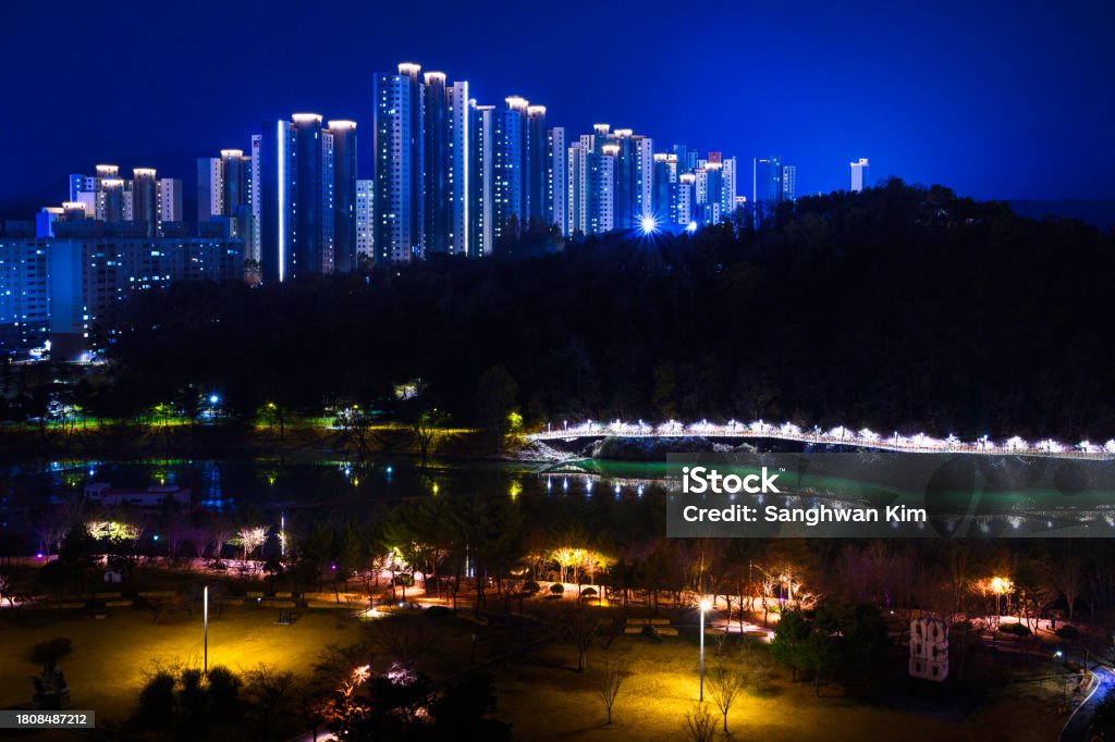 Chuncheon City night skyline and buildings on the pine forest hill in South Korea. Illuminated Gongjicheon Amusement Park along the Soyanggang River and Samaksan Mountains view in Gangwon-do Amusement Park Stock Photo