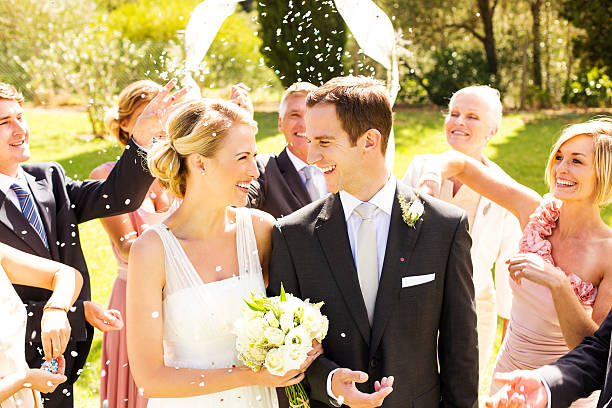 istock Newlywed Bride And Groom With Guests Throwing Confetti On Them 180848823