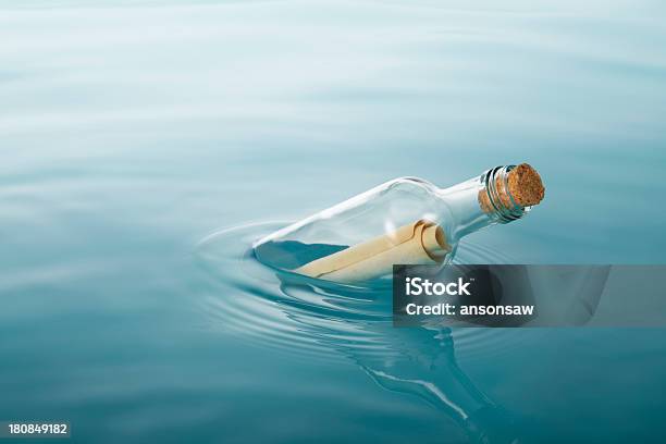 A Message Inside Of A Bottle Floating In The Water Stock Photo - Download Image Now