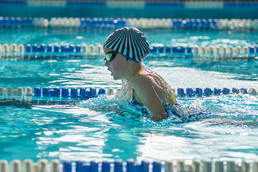 Swimmers racing in a competitive outdoor swim meet.