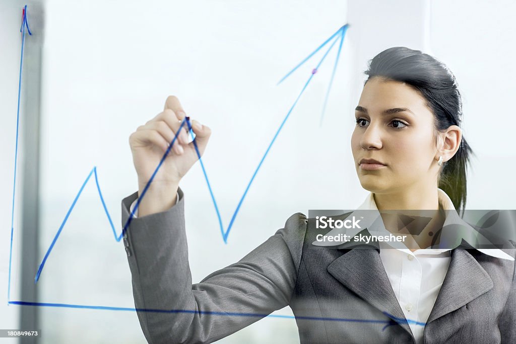 Business woman drawing graph. Young business woman drawing graph.   Adult Stock Photo