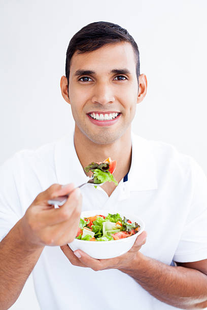 istock Latin man eating salad 180849763