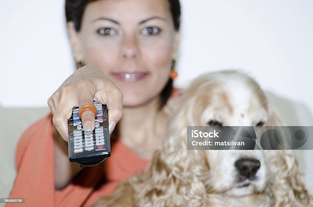 Woman with a TV remote control Woman with a TV remote control and a cocker spaniel dog Adult Stock Photo