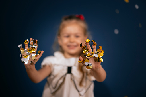 Close up shot of an anonymous little girl with her hands covered in big glitter.