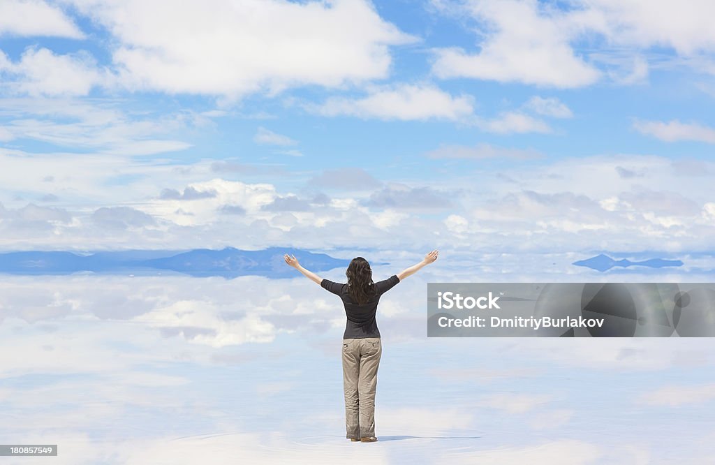 Woman with hands raised Rear view of woman worshiping in nature, Salar de Uyuni, Bolivia Rear View Stock Photo