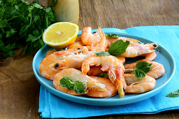 istock shrimp cooked with lemon and basil on a wooden table 180859407