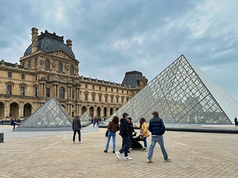 Paris, France - April 11 2023: carroussel du louvre glass pyramid on court yard of louvre museum and visitors