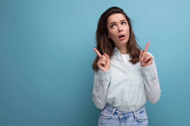 istock pensive young brunette woman in shirt on studio background 1808603188