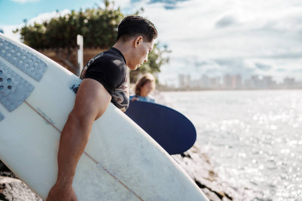 istock Fit young man heading out to surf in Hawaii 1808605500