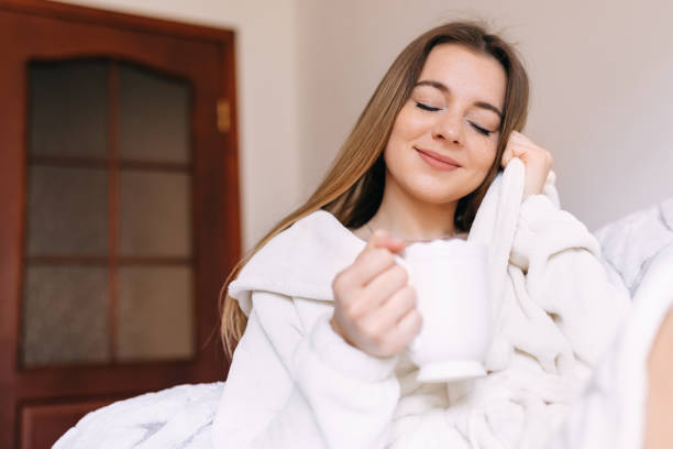 istock pretty cute girl drinks coffee from white cup at home 1808608873