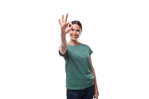 young brunette woman in love with collected hair is dressed in a basic t-shirt and jeans.