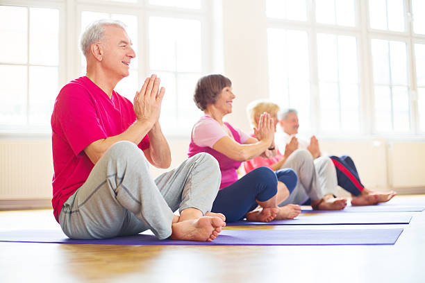 heureux les retraités faire du yoga - praying joy indoors lifestyles photos et images de collection