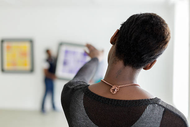 istock Female black Gallery owner hanging a picture 180864510