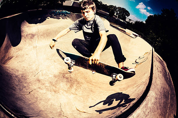 Young active man jumping ollie trick on skateboard and isolated on white background