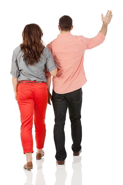 istock Rear view of a couple walking while man waving 180865070