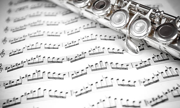 Flute keys on music notes stock photo