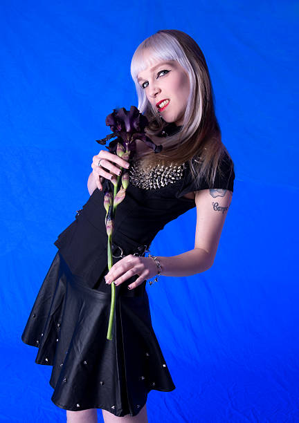 istock Young woman holding Black Beauty iris on blue. 180866360