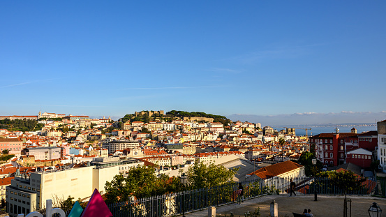 Lisbon. Bridge and Jesus Christ in background. Rooftops. Sunny spring day.