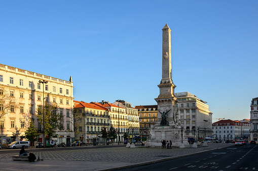 Lisbon, Portugal - Nov 14, 2023: Evening warm sunlight shines on the Monument and the Restauradores Square.