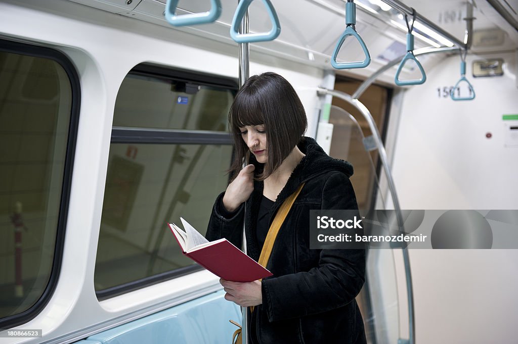 Jovem mulher a ler um livro no Comboio de Metropolitano - Royalty-free Compartimento de Comboio Foto de stock