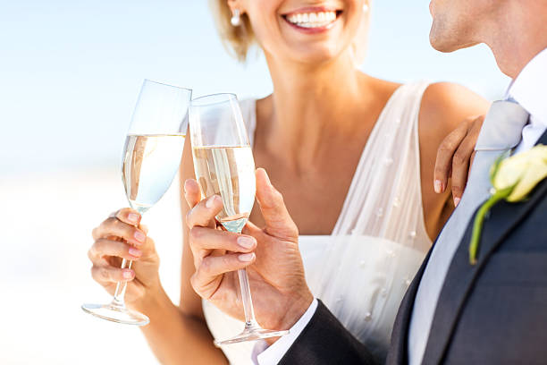 sposi brindando con champagne sulla spiaggia - wedding beach bride groom foto e immagini stock