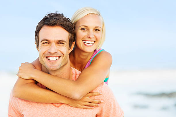 istock Woman Embracing Man From Behind At Beach 180867611