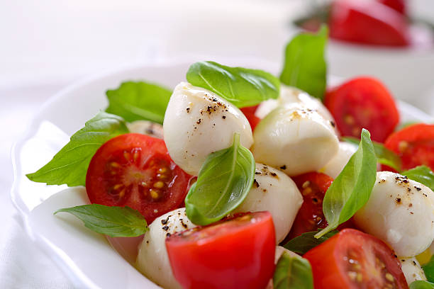 Caprese Salad Caprese salad with mozzarella cheese,tomato,basil, olive oil and pepper caprese salad stock pictures, royalty-free photos & images