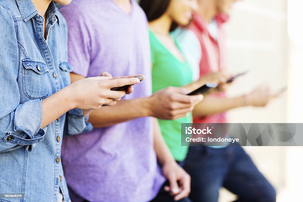 Groupe d'adolescents à envoyer des SMS sur le téléphone intelligent - Photo de 16-17 ans libre de droits