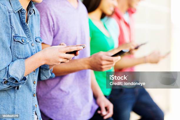 Foto de Grupo De Adolescentes Mensagens De Texto No Telefone Inteligente e mais fotos de stock de 16-17 Anos