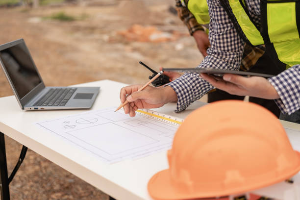 istock Concept architect, engineer, team holding pen, pointing architect, equipment on table with blueprints, ready to discuss home design in office. 1808685473