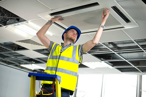 istock electrician fitting air conditioning to office interior 180868551