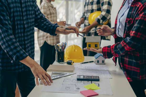 istock Concept architect, engineer, team holding pen, pointing architect, equipment on table with blueprints, ready to discuss home design in office. 1808686532